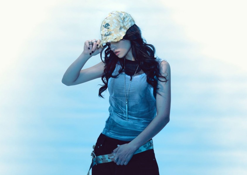 Ari Abdul wearing black trousers, a white vest, and a capx